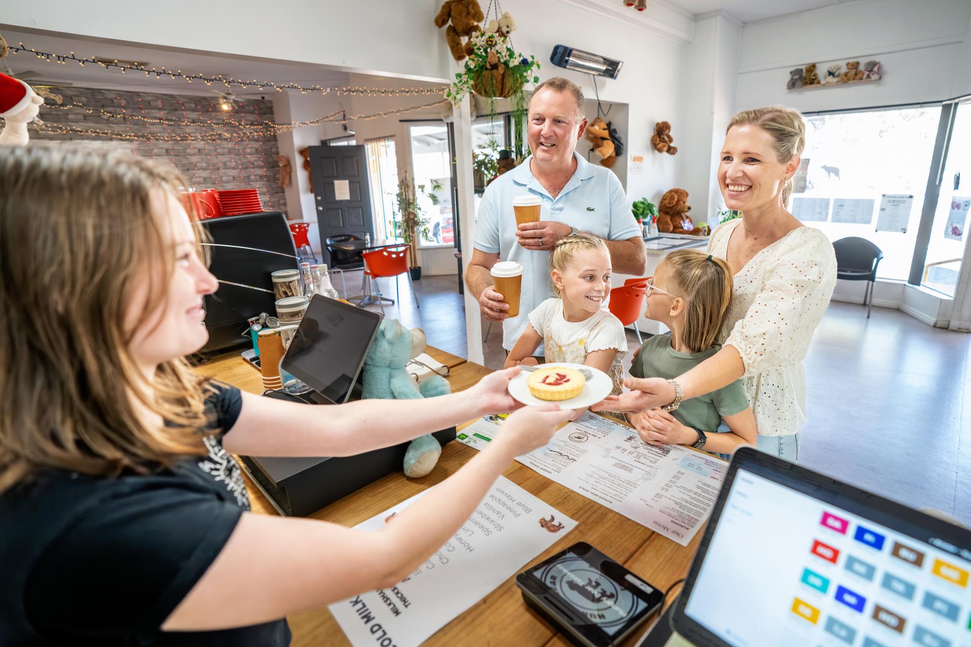 Picture of Hungry Bear Employee serving family a dessert over the counter.