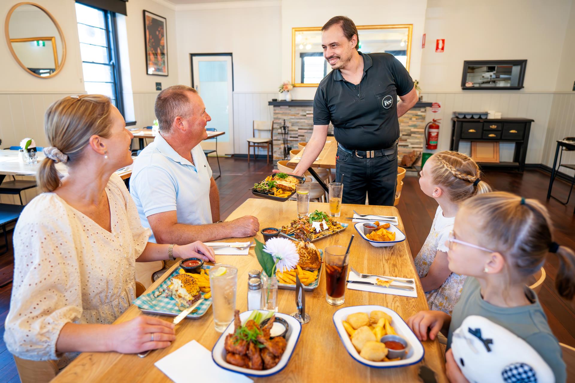 Picture of family sitting down at The Rec being served delicious food by friendly employee.